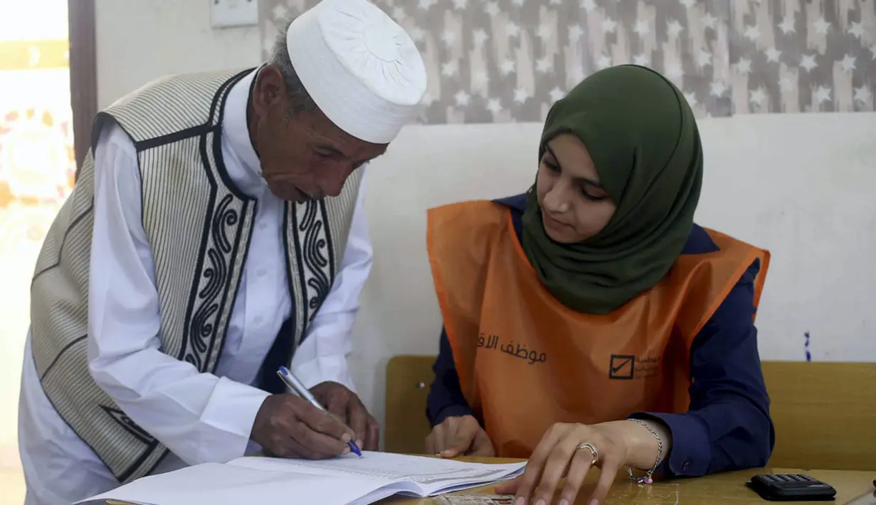 Sebelum masuk ke bilik suara, warga Libya diwajibkan melakukan pendaftaran di Tempat Pemungutan Suara. Tampak salah satu warga Libya sedang melakukan pendaftaran di sebuah TPS di Benghazi, (25/6/2014). (REUTERS/Esam Omran Al-Fetori)