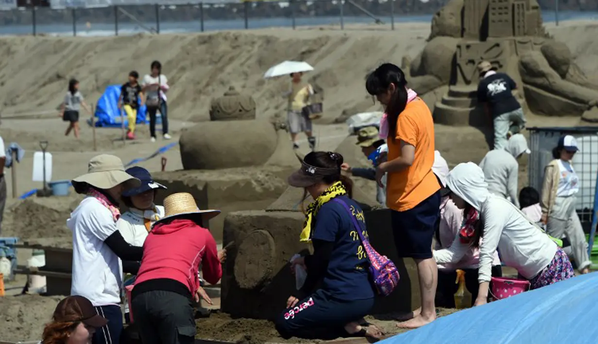 Pengunjung bermain pasir saat pameran Asahi Sand Sculpture, Yasashigaura, pantai Asahi, Tokyo, Sabtu (11/7/2015). Pameran ini digelar mulai Senin (6/7) lalu. (AFP PHOTO/Toshifumi Kitamura)