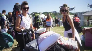 Dua wanita mengenakan kaca mata saat tiba di hari pertama Festival Glastonbury di Worthy Farm di Somerset, Inggris, Rabu (22/6/2022). Lebih dari 200.000 penggemar musik dan megabintang Paul McCartney, Billie Eilish, dan Kendrick Lamar turun ke pedesaan Inggris minggu ini saat Festival Glastonbury kembali setelah festival jeda tiga tahun. (Yui Mok/PA via AP)