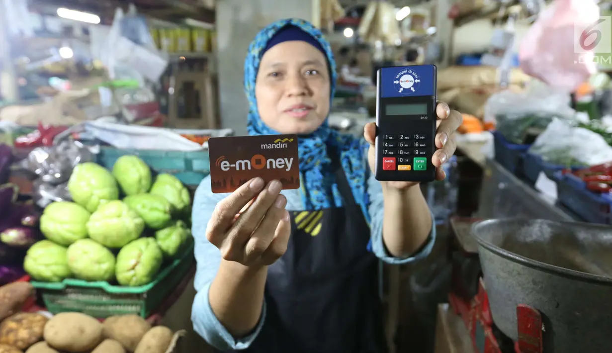 Pedagang menunjukkan kartu E-Money dan mesin Q Cash di PD Pasar Jaya  Mayestik, Jakarta, Rabu (4/4). Program pembayaran ini merupakan bentuk dukungan pada gerakan nasional non tunai. (Liputan6.com/Angga Yuniar)