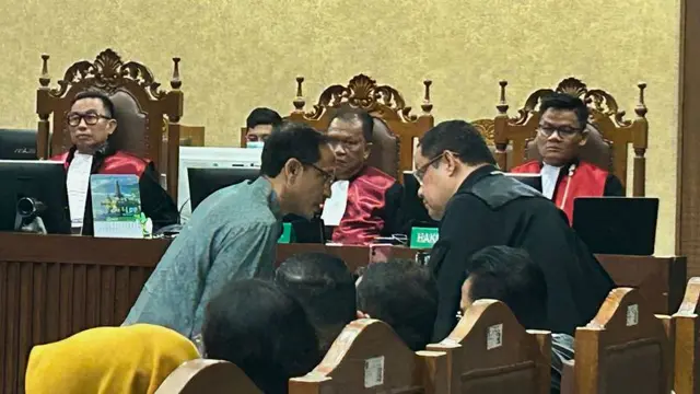 Terdakwa kasus dugaan korupsi Chromebook, Nadiem Anwar Makarim (kiri) berkonsultasi dengan penasihat hukum dalam sidang dakwaan di Pengadilan Tipikor pada PN Jakpus