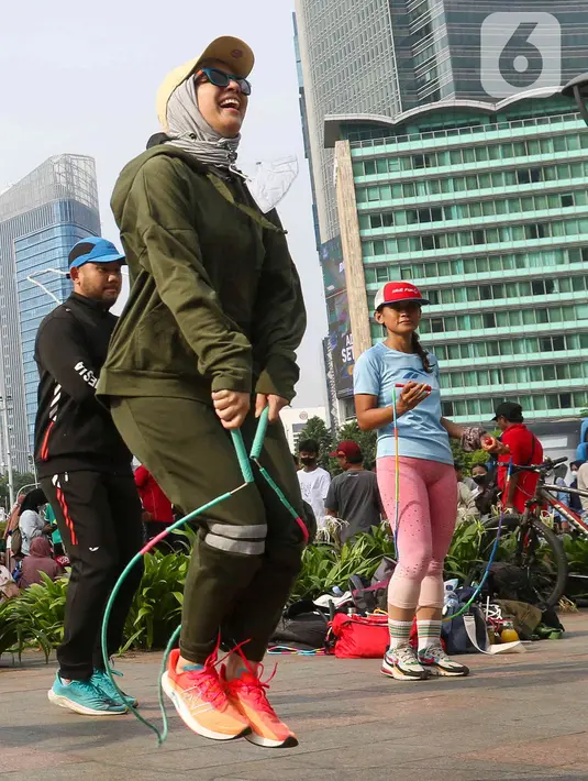 Aktris Tya Ariestya bermain lompat tali saat Car Free Day di kawasan bundaran Hotel Indonesia, Jakarta, Minggu (12/6/2022). Tya Ariestya menjaga tubuh tetap bugar dengan berolahraga salah satunya lompat tali. (Liputan6.com/Herman Zakharia)