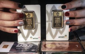 Petugas menunjukkan koleksi lempengan emas di Pegadaian, Jakarta, Selasa (18/5/2021). Harga emas batangan PT Aneka Tambang Tbk. (Antam) pada 17 Mei 2021 berada di posisi lebih tinggi dibanding hari sebelumnya. (Liputan6.com/Johan Tallo)