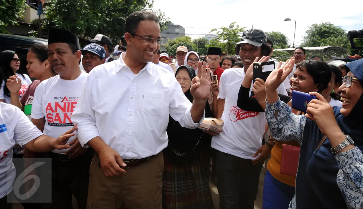 Cagub DKI Jakarta, Anies Baswedan (kiri) disambut warga jelang sosialisasi di Rusun Karet Tengsin, Jakarta, Rabu (28/12). Anies juga melantik koordinator tim pemenangan tingkat Rt dan Rw di Karet Tengsin. (Liputan6.com/Helmi Fithriansyah)