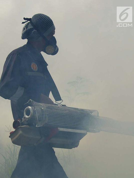 Petugas dari Puskesmas Kecamatan Cengkareng melakukan pengasapan (fogging) untuk membasmi nyamuk Demam Berdarah di Kawasan Kedaung, Jakarta Barat, Selasa (23/4). Pengasapan (fogging) dilakukan sebagai langkah pengendalian vektor nyamuk DBD . (merdeka.com/Imam Buhori)