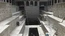 Orang-orang mandi di sumur tangga Bansilalpet berusia abad ke-18 yang sedang menjalani pekerjaan restorasi di Secunderabad, kota kembar Hyderabad, India (24/8/2022). (AFP/Noah Seelam)