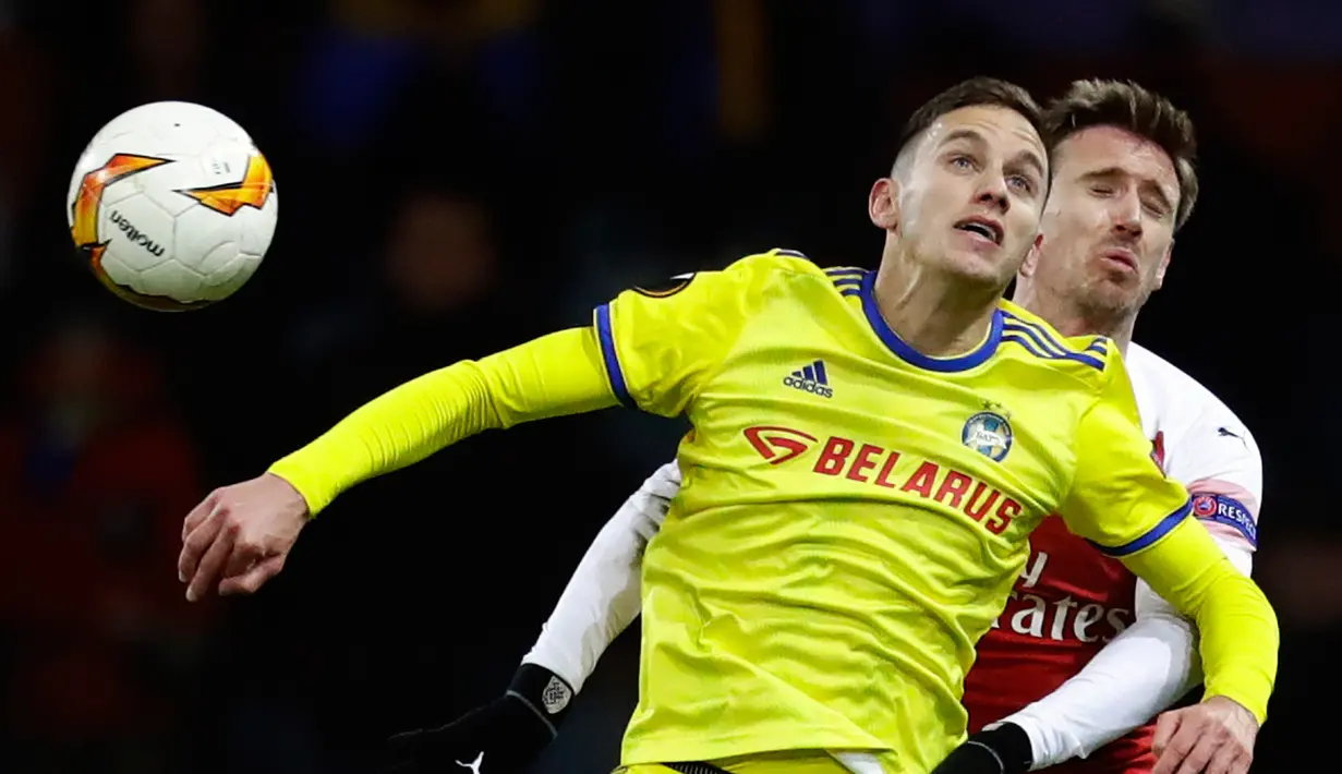 Pemain BATE Borisov, Boate Dubajic berebut bola dengan pemain Arsenal, Nacho Monreal pada leg pertama 32 besar Liga Europa di Borisov Arena, Kamis (14/2). Arsenal kalah dengan skor 0-1 saat bertandang ke markas Bate Borisov. (AP/Sergei Grits)