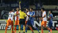 Wasit memberikan kartu kuning kepada pemain Pusamania Borneo FC, Jajang Mulyana dalam laga leg kedua perempatfinal Piala Presiden 2015 di Stadion Si Jalak Harupat, Bandung, Sabtu (26/9/2015). (Bola.com/Arief Bagus)