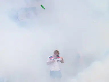 Seorang suporter Inggris terjebak dalam gas air mata yang dilepaskan polisi saat terjadi keributan antar suporter di Marseille, Prancis, (10/6/2016), jelang pertandingan melawan Rusia. (AFP/Leon Neal)