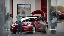 Pengunjung melihat mobil Tesla model 3 di sebuah dealer di Chicago, Illinois (30/3). Produsen mobil listrik Tesla mengkonfirmasi keterlibatan sistem autopilot kendaraannya dalam kecelakaan fatal pada 23 Maret 2018 lalu. (Scott Olson / Getty Images / AFP)