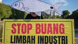 Seorang aktivis dari Ecoton (Ecological Observation and Wetlands Conservation) yang mengenakan masker ikan mengikuti unjuk rasa menyerukan sungai bersih bebas sampah dan limbah industri, serta perlindungan ikan sungai, sebagai bagian dari perayaan Hari Lingkungan Hidup Sedunia di Surabaya, Jawa Timur, Jumat 5 Juni 2026. (JUNI KRISWANTO/AFP)