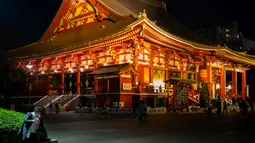 Seorang wanita melihat ponselnya di dekat kuil Asakusa di Tokyo (1/12). Pada abad kedua puluh, Asakusa adalah daerah hiburan utama di Tokyo. (AFP Photo/Martin Bureau)