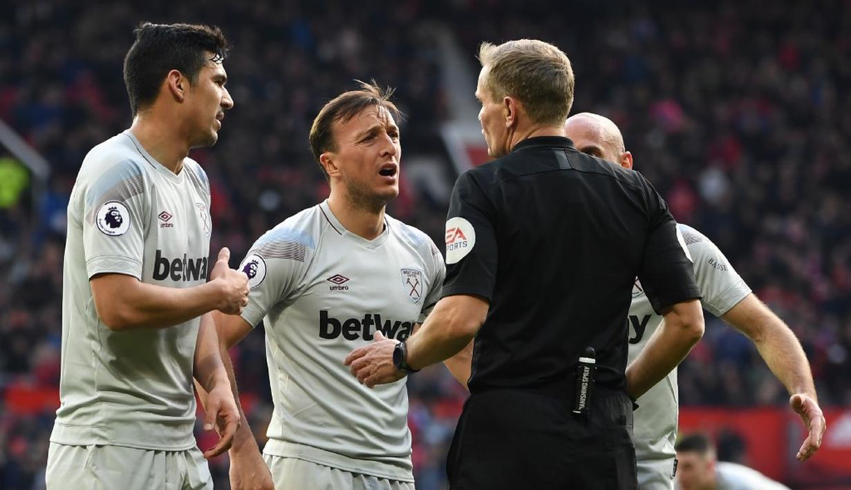 Protes dilakukan kapten West Ham, Mark Noble pada laga lanjutan Premier League yang berlangsung di Stadion Old Trafford, Minggu (14/4). Man United menang 2-1 atas West Ham. (AFP/Paul Ellis)