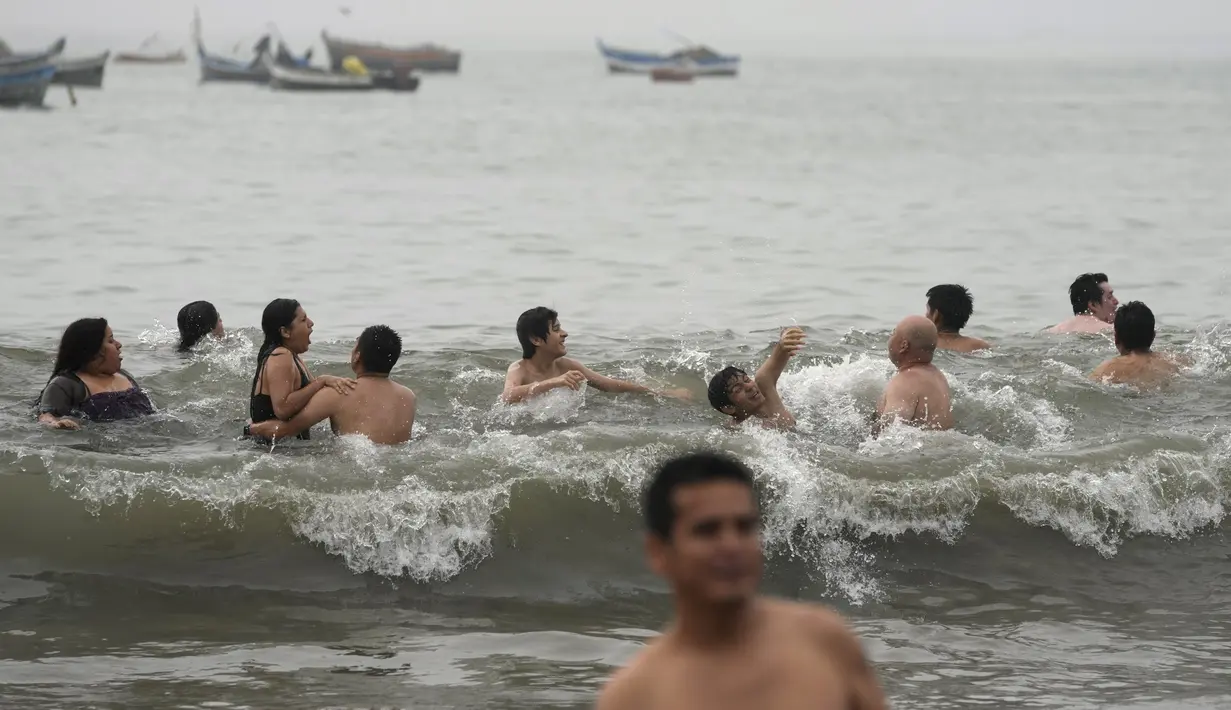Orang-orang bersenang-senang di pantai Agua Dulce di Lima, Peru, Minggu (29/1/2023). Pengunjuk rasa yang melakukan protes dan blokade, yang berdampak pada tambang-tambang di negara penghasil tembaga terbesar kedua di dunia itu menuntut Kongres dan Presiden Dina Boluarte untuk mundur. (AP Photo/Rodrigo Abd)