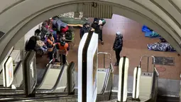 Suasana tegang menyelimuti stasiun kereta bawah tanah di tengah invasi Rusia ke Ukraina. Tampak dalam foto, orang-orang berlindung di stasiun metro saat serangan udara Rusia di Kyiv pada Selasa 25 November 2025, di tengah invasi Rusia ke Ukraina. (Yan Dobronosov/AFP)