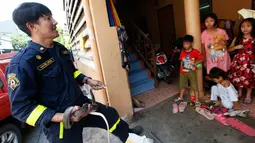 Petugas pemadam kebakaran Phinyo Pukphinyo menangkap ular yang berada di rumah warga di Bangkok, Thailand (6/11). Ular yang ditangkap petugas Thailand tersebut akan dikembalikan ke alam bebas. (AP Photo/Sakchai Lalit)