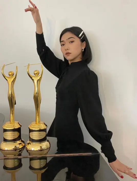 Raih penghargaan Ami Awards 2021, Isyana tampil mengenakan dress panjang hitam berkerah cheongsam dengan kancing depan dan detail lengan bergelembung. (Instagram/isyanasarasvati).