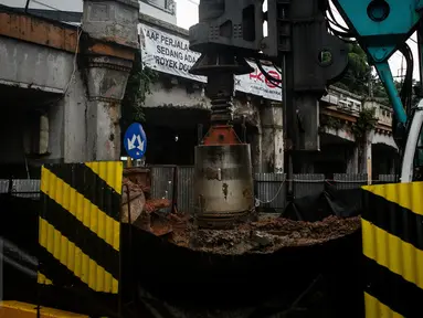 Alat berat membuat lubang untuk pemasangan tiang pancang proyek double-double track (DDT) Paket A Manggarai-Jatinegara, Jakarta, Minggu (26/3). Proses pengerjaan Paket A jalur Manggarai-Jatinegara terus di kebut. (Liputan6.com/Faizal Fanani)