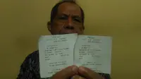 Dosen Unhas menunjukkan slip transfer dari rekeningnya yang diambil penghipnotis. (Liputan6.com/Eka Hakim)