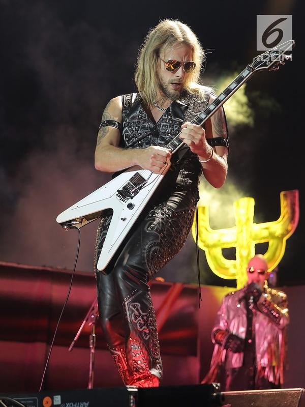 Aksi panggung gitaris Judas Priest Richie Faulkner selama konser perdana di Indonesia di Allianz Eco Park Ancol, Jakarta Utara (7/12). Total lagu yang dibawakan oleh Judas Priest sebanyak 19 lagu di konser tersebut. (Fimela.com/Bambang E. Ros)