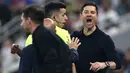 Xabi Alonso berusaha meredam aksi panas tersebut. Ia mencoba menahan dan menenangkan pemainnya, Vinicius Jr. (AFP/Fadel Senna)