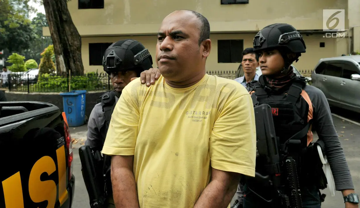 Pelaku pengeroyokan dan penganiayaan, Edwin Hitipeuw dikawal oleh polisi saat dibawa ke Polda Metro Jaya, Jakarta (12/7). Dari hasil pemeriksaan sementara, penganiayaan dilakukan karena motif bersenggolan mobil di jalan Tol Jagorawi. (Liputan6.com/Pool)