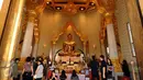 Pengunjung berdoa di depan Golden Budha di kota Bangkok, Thailand, Sabtu (17/12). Salah satu biksu yang ada di kuil tersebut memprediksi hasil laga final kedua Piala AFF 2016 antara Thailand melawan Indonesia. (Liputan6.com/Helmi Fithriansyah)