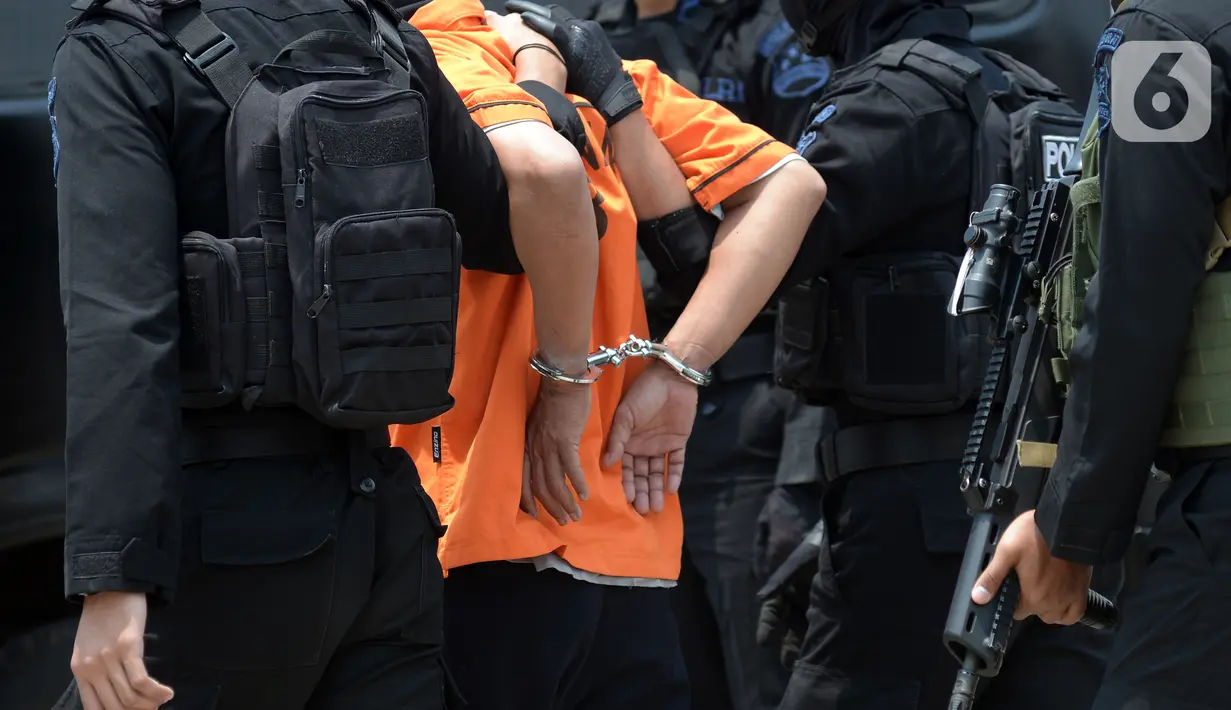 Tangan terduga teroris diborgol saat digiring anggota Densus 88 Antiteror setibanya di Bandara Soekarno-Hatta, Tangerang, Banten, Kamis (18/3/2021). Polri memindahkan 22 terduga teroris jaringan kelompok Jamaah Islamiyah (JI) dari Jawa Timur ke Jakarta. (merdeka.com/Imam Buhori)