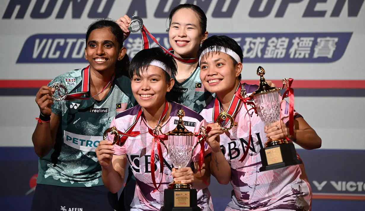 Juara ganda putri Hong Kong Open 2023, pasangan Indonesia, Apriyani Rahayu/Siti Fadia Silva Ramadhanti berfoto bersama peringkat kedua, pasangan Malaysia Pearly Tan/Thinaah Muralitharan setelah upacara penyerahan trofi dan hadiah Hong Kong Open 2023 di Hong Kong Coliseum, Minggu (17/9/2023) siang WIB. Apriyani/Siti Fadia menjadi juara setelah menang rubber game 14-21, 24-22 dan 21-9. (AFP/Peter Parks)