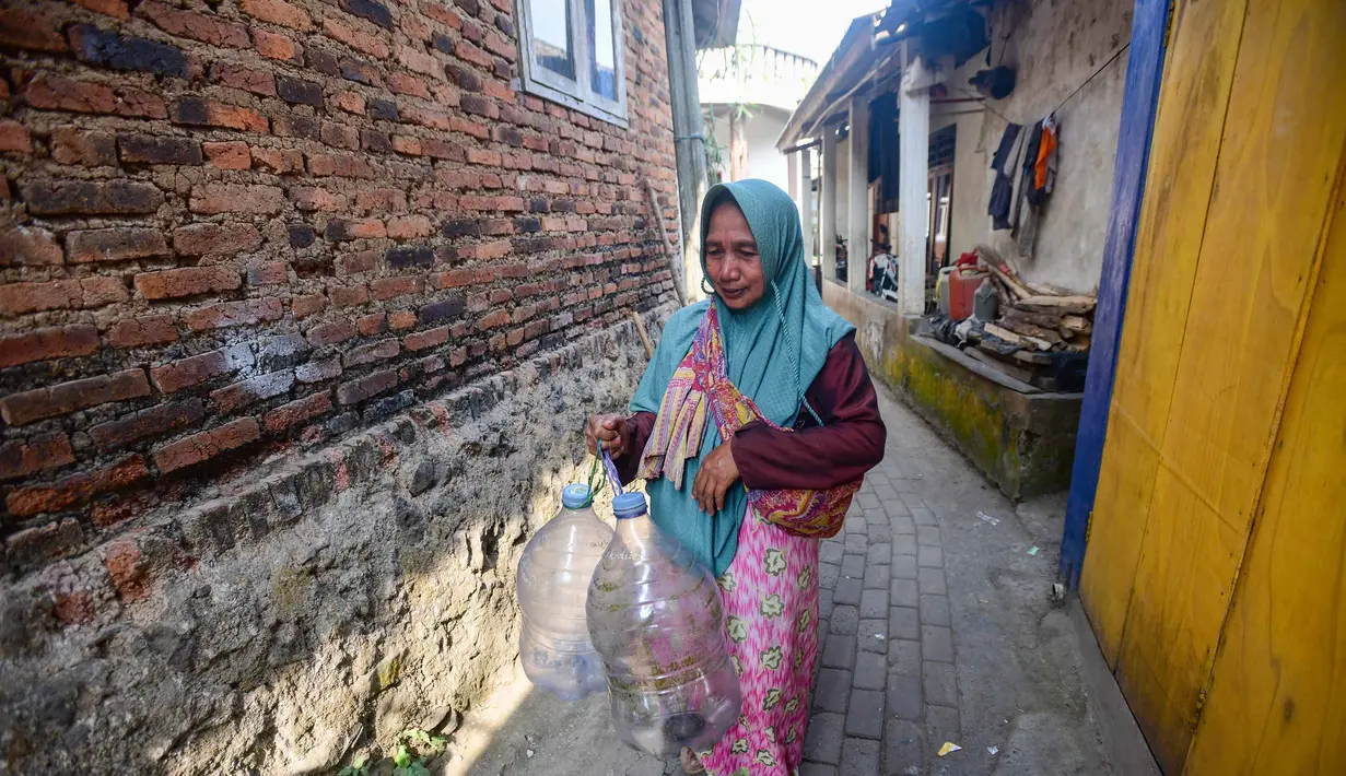 Warga berjalan untuk mengambil air untuk minum dan kebutuhan mck rumah  di sumber mata air Sumur Bendung, Gunung Batur, Kota Cilegon, Banten, Minggu, (15/7/2026). (KLY/Arie Basuki)