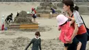 Warga mengunjungi pameran Asahi Sand Sculpture di pantai Yasashigaura, Asahi, Chiba, (13/7/2014). Diharapkan, pameran patung pasir ini mampu menarik minat sekitar 50.000 wisatawan. (AFP PHOTO/Toshifumi Kitamura)