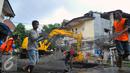 Petugas mengangkat besi Jembatan Inspeksi Kali Grogol yang ambles di Komplek Hankam, Slipi, Jakarta, Senin (21/3). Dinas Pemprov DKI sedang melakukan perbaikan di kawasan depan Komplek HANKAM slipi Jakarta Barat. (Liputan6.com/Faisal R Syam)