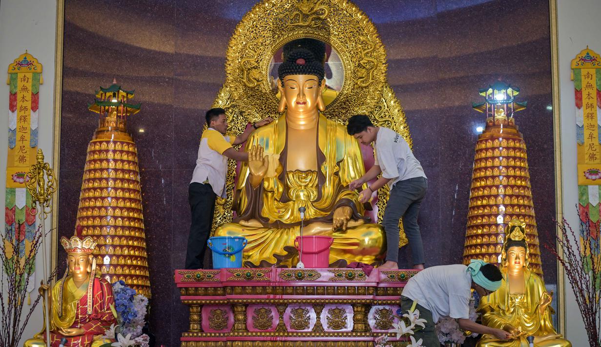 Tradisi ini menjadi simbol penyucian hati dan pikiran umat Buddha sebagai persiapan menyambut lembaran baru di tahun mendatang. Tampak dalam foto, warga membersihkan patung Buddha dalam persiapan perayaan Tahun Baru Imlek 2577 Kongzili di Vihara Buddhayana, Surabaya, Jawa Timur pada Senin 9 Februari 2026. (JUNI KRISWANTO/AFP)