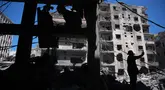 Warga memeriksa dan membersihkan puing-puing dari bangunan yang rusak akibat serangan Israel di kota pelabuhan Tyre, Lebanon Selatan, Kamis 18 Juni 2026. (AP Photo/Hassan Ammar)