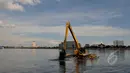 Tampak salah satu alat berat saat mengeruk sampah di Waduk Pluit, Jakarta, Kamis (30/4/2015). Pengerukan waduk pluit  dilakukan selain untuk mengurangi sampah - sampah di waduk juga untuk keindahan waduk. (Liputan6.com/JohanTallo)