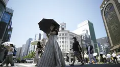 Orang-orang berjalan di atas penyeberangan pejalan kaki di bawah terik matahari di Tokyo, Selasa (28/6/2022). Pemerintah Jepang mengeluarkan peringatan untuk kemungkinan pemadaman listrik di wilayah Tokyo pada hari Senin (27/6), meminta kantor dan penduduk untuk menghemat energi karena wilayah ibu kota dilanda panas terik. (AP Photo/Eugene Hoshiko)