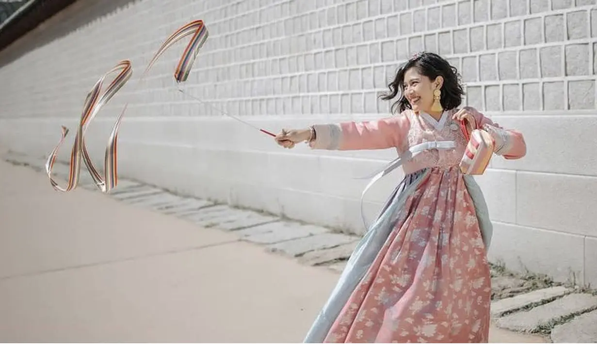 Dian Sastro tampak ceria mengenakan hanbok yang didominasi warna pink, namun ia memilih tidak mengenakan aksesori seperti eoni Korea.  (@therealdisastr)