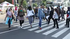 Warga melintasi Pelican Crossing di sekitar Halte Transjakarta Gelora Bung Karno, Jakarta, Jumat, (30/11). Penyeberangan pelican crossing diberlakukan selama revitalisasi jembatan penyeberangan orang (JPO) berlangsung. (Liputan6.com/Helmi Fithriansyah)