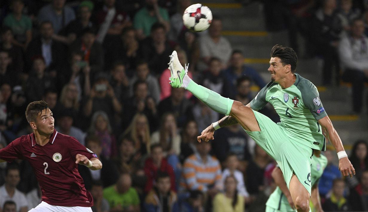 Bek Portugal, Jose Fonte, membuang bola dari bek Latvia, Vitalijs Maksimenko, pada laga kualifikasi Piala Dunia 2018 di Stadion Skonto, Riga, Jumat (9/6/2017). Latvia kalah 0-3 dari Portugal. (AP/Roman Koksarov)