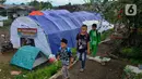 Murid-murid korban gempa belajar usai sekolah pada tenda di halaman sekolah di SDN Gintung, Mangunkerta, Cianjur, Jumat (23/12/2022). Lebih dari sebulan sejak musibah gempa bumi 5,2 SR sejumlah murid sekolah di Cianjur masih belajar pada tenda darurat. (merdeka.com/Arie Basuki)