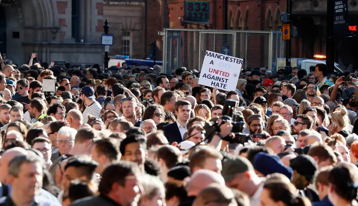 Ribuan orang memadati Albert Square di pusat kota Manchester, Selasa (23/5). Mereka menunjukkan solidaritas dengan doa bersama untuk korban bom di konser Ariana Grande yang menewaskan 22 orang dan melukai 119 lainnya. (AP Photo/Kirsty Wigglesworth)