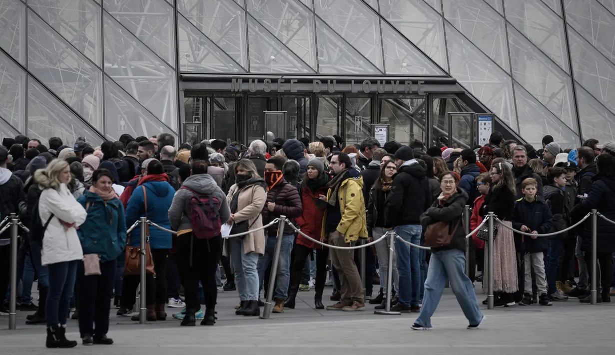 Pengunjung mengantre di depan Pyramid, pintu masuk utama menuju museum Louvre, di Paris, Rabu (4/3/2020). Louvre di Paris, museum yang paling banyak dikunjungi di dunia, kembali dibuka setelah pegawai yang khawatir dengan penularan virus corona setuju kembali masuk kerja. (Philippe LOPEZ/AFP)