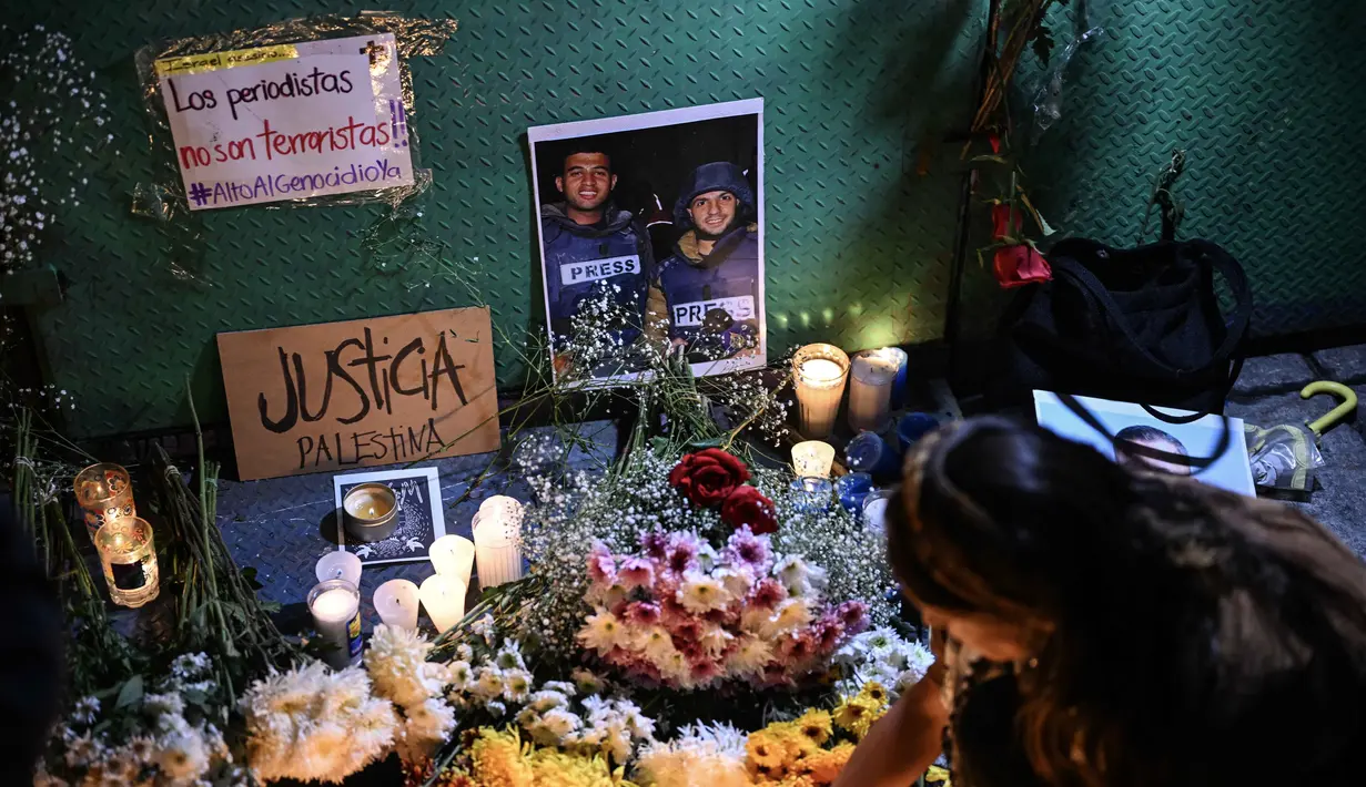 Seorang wanita meletakkan lilin di altar sebagai penghormatan bagi jurnalis yang tewas akibat serangan Israel di Jalur Gaza, saat menghadiri doa bersama di Mexico City pada 12 Agustus 2025. (Yuri CORTEZ/AFP)