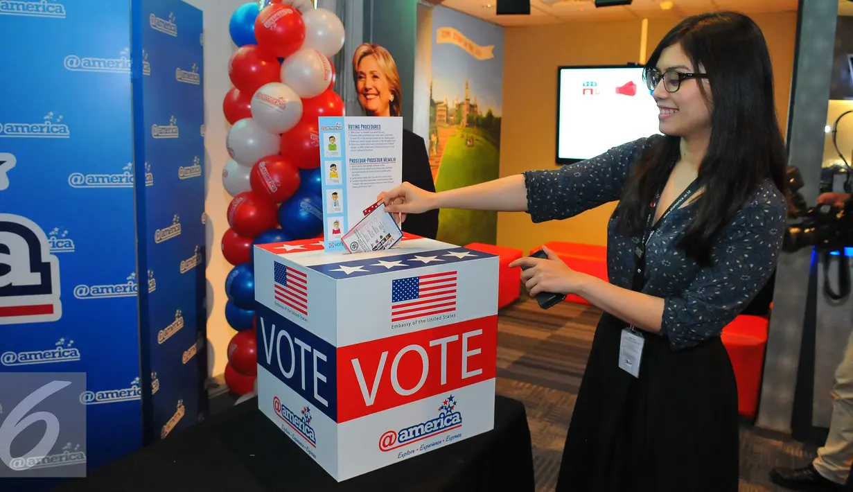 Pengunjung wanita memasukan selembaran voting saat mengikuti simulasi pemilihan Presiden Amerika Serikat di @america di Jakarta, Rabu (9/11). Dalam simulasi ini pengunjung dapat merasakan pemilihan presiden AS mirip aslinya. (Liputan6.com/Angga Yuniar)