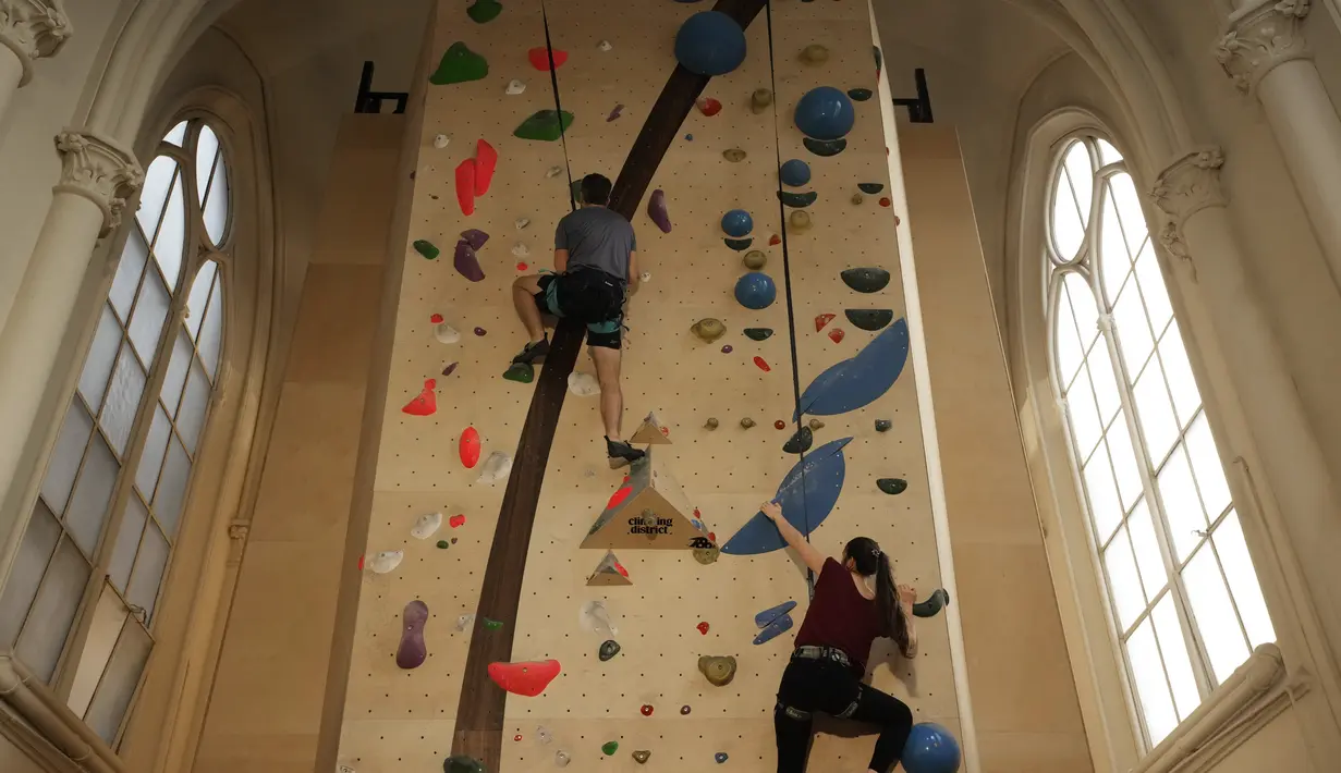Peserta berlatih memanjat di lokasi Climbing District di Paris, Rabu, 11 Januari 2023. Tembok panjat buatan baru ini dibuka pada November 2022 di dalam bekas kapel abad ke-19, bernama le couvent des Oblats de Marie-Immaculee. (AP Photo/Christophe Ena)