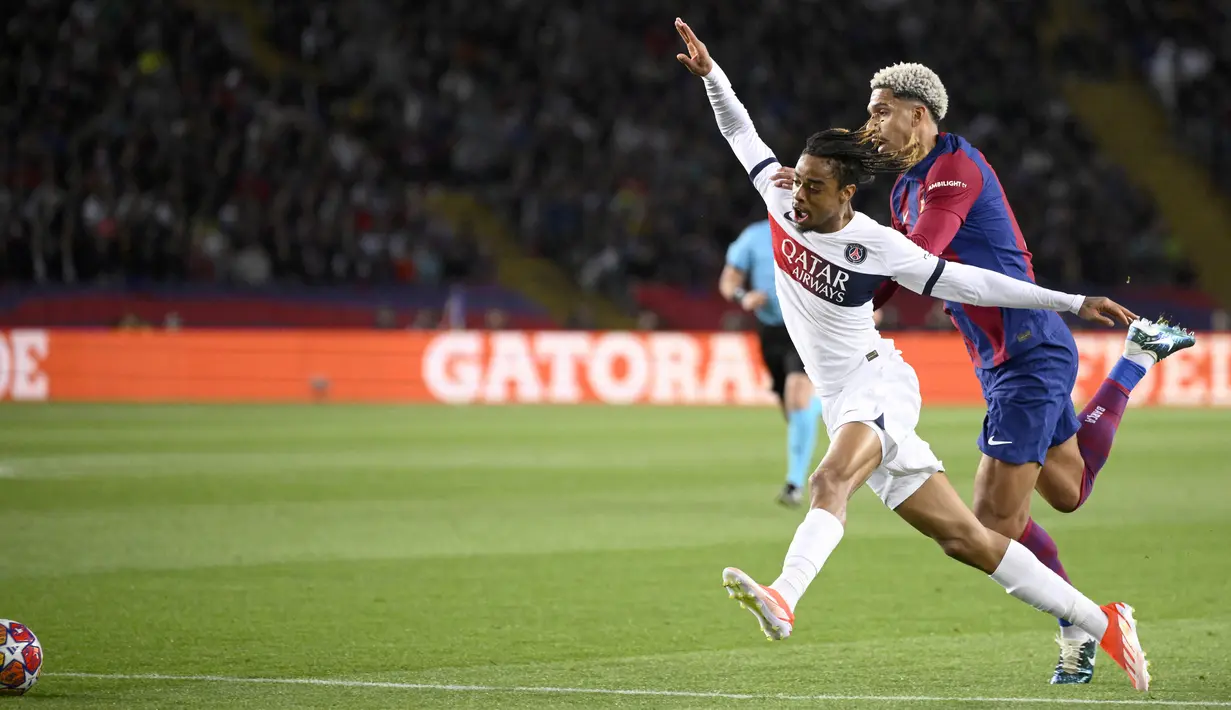Pemain Barcelona, Ronald Araujo, melakukan pelanggaran terhadap pemain Paris Saint-Germain, Bradley Barcola, pada duel leg kedua perempat final Liga Champions 2023/2024 Stadion Olimpic Lluis Companys, Rabu (17/4/2024). (AFP/Josep Lago)