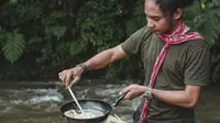 Potret Foel La Ode ketika memasak di dekat sungai. (Dok: Instagram @laode.mci8 https://www.instagram.com/p/CW9sRbGPULK/?igshid=YmMyMTA2M2Y= / Elly Purnama)