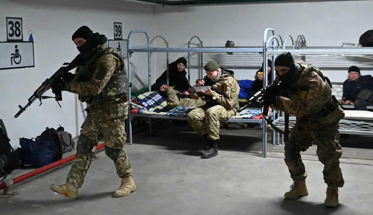 Pasukan Pertahanan Teritorial Ukraina, cadangan militer Angkatan Bersenjata Ukraina, makan siang sementara yang lain berlatih di garasi bawah tanah yang telah diubah menjadi pangkalan pelatihan dan logistik di Kiev, pada Jumat (11/3/2022). (Sergei SUPINSKY / AFP)