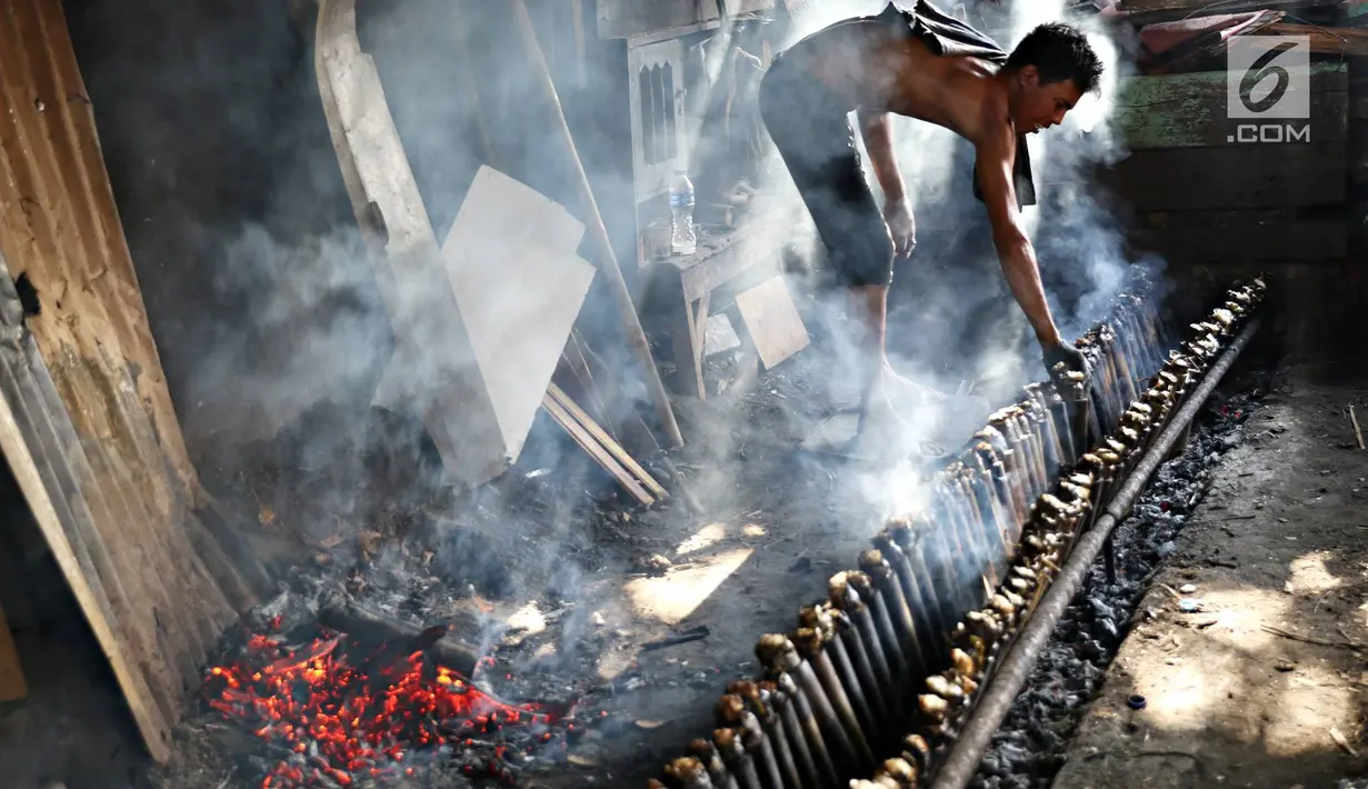 Sejumlah pekerja membakar lemang di Kawasan Senen, Jakarta, Selasa (30/5). Selama Ramadan, permintaan makanan berbahan ketan khas Sumatera ini menjadi makanan favorit warga untuk sajian berbuka puasa. (Liputan6.com/Immanuel Antonius)