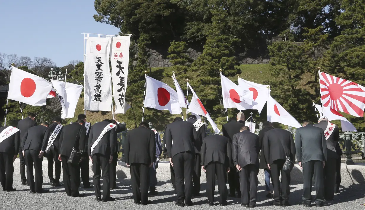 Simpatisan mengibarkan bendera nasional Jepang di dekat Istana Kekaisaran untuk merayakan ulang tahun ke-60 Kaisar Naruhito di Tokyo, Minggu, (23/2/2020). Ini merupakan pembatalan ulang tahun kaisar pertama sejak 1996. (AP Photo/Koji Sasahara)